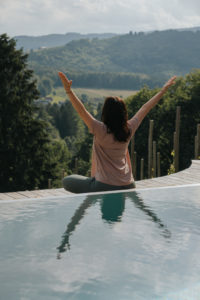 Yoga im Urlaub am Pool mit Blick in die Weinberge, Steiermark, Österreich